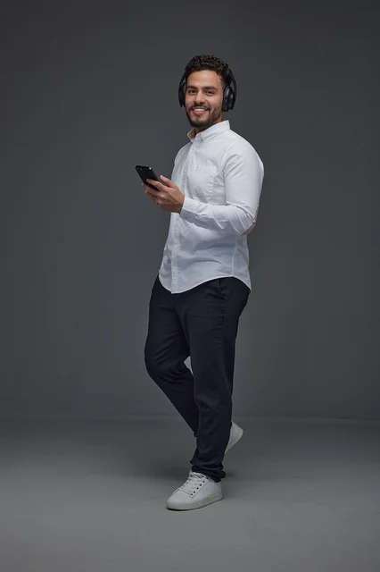 Saudi Man with Headphones Using Smartphone in Studio Saudi Man with Headphones Using Smartphone in Studio