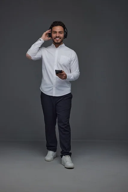 Saudi Man Using Smartphone and Headphones in Studio Saudi Man Using Smartphone and Headphones in Studio