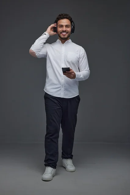 Saudi Man with Headphones and Smartphone on Grey