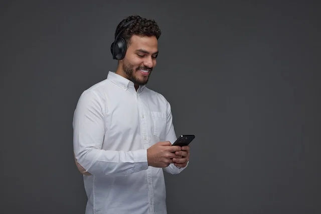 رجل سعودي يستخدم الهاتف الذكي مع سماعات الرأس