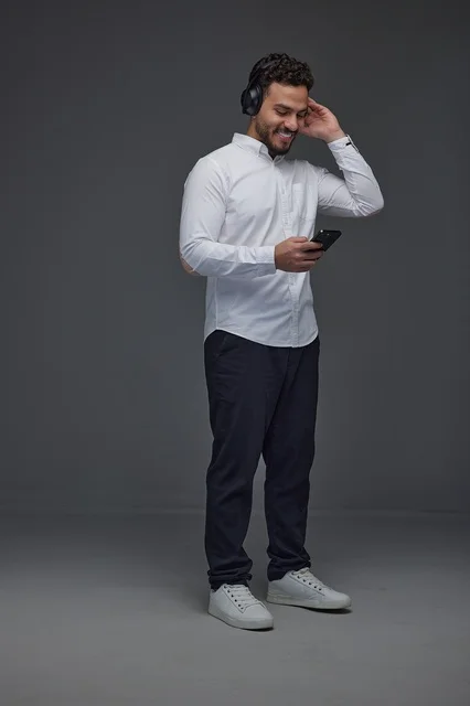 Saudi Man Using Smartphone and Headphones in Studio