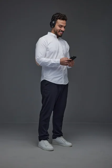 Saudi Man with Headphones Using Smartphone in Studio