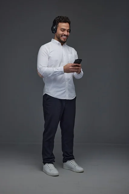 Saudi Man Using Smartphone with Headphones in Studio