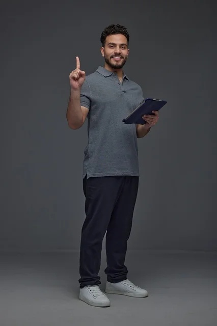 Saudi Man with Tablet Pointing Up in Studio Setting