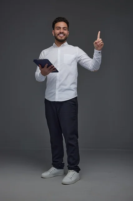 Smiling Saudi Man Holding Digital Tablet and Pointing Up