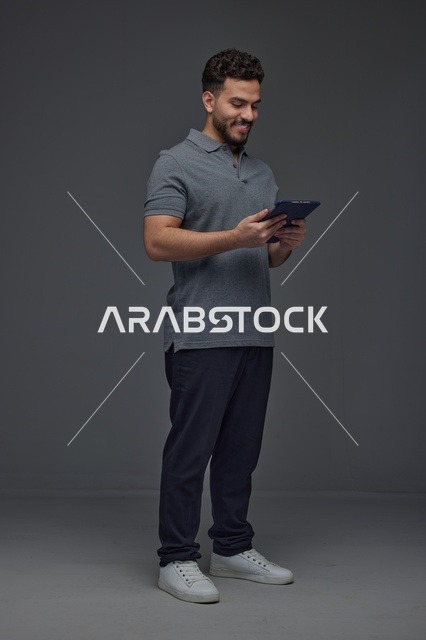 رجل سعودي يستخدم جهازاً لوحياً في الاستوديو