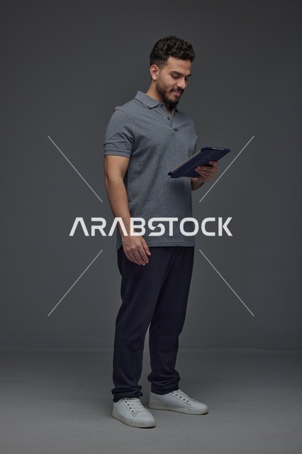 رجل سعودي يستخدم جهازاً لوحياً في الاستوديو