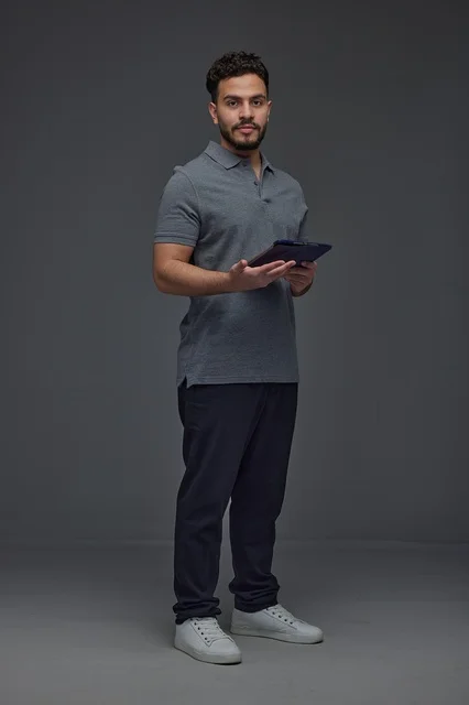 Saudi Man Holding Digital Tablet on Gray Background