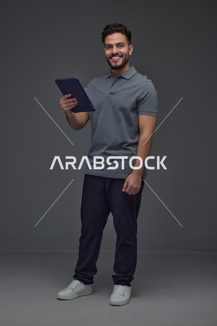 رجل سعودي يستخدم جهازًا لوحيًا ويتفاعل مع الكاميرا