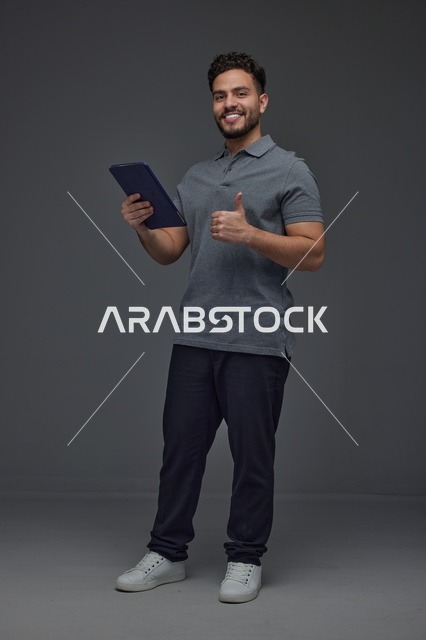 Saudi Man with Tablet Giving Thumbs Up in Studio