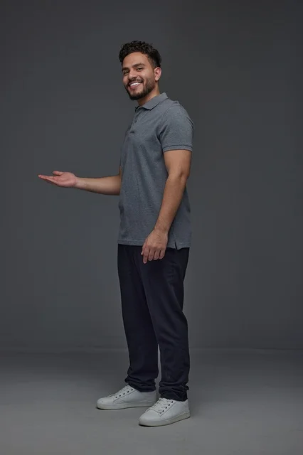 Smiling Saudi Man Presenting on Grey Studio Background