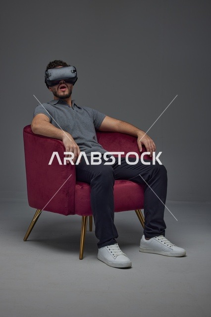 Saudi Man Using VR Headset in a Red Velvet Armchair