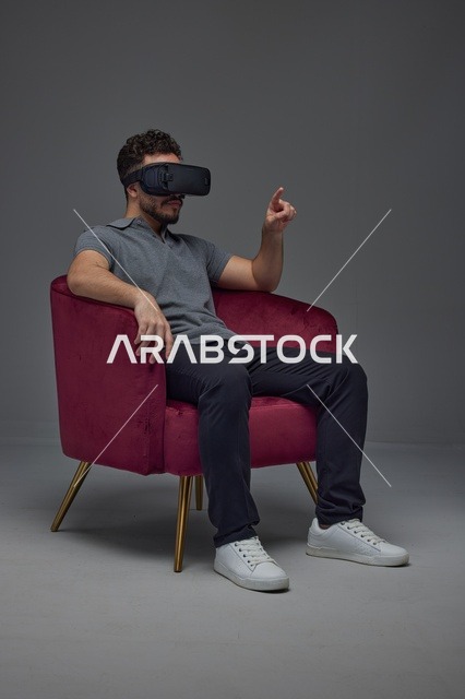 Saudi Man Using VR Headset in Red Velvet Chair