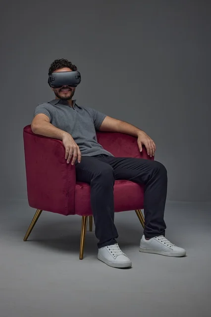Saudi Man Wearing Virtual Reality Headset in Red Armchair