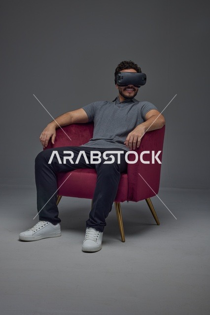 Saudi Man Wearing VR Headset in Armchair Studio