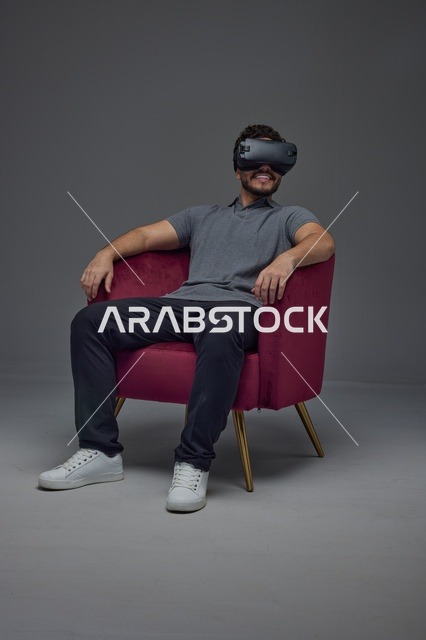 Saudi Man Wearing VR Headset in Red Armchair Studio