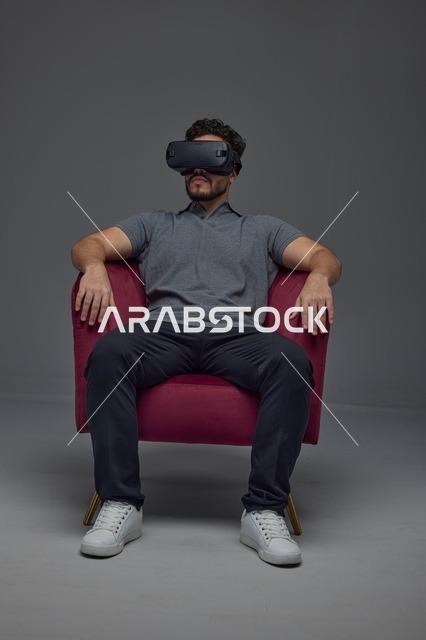 رجل سعودي يستخدم نظارة الواقع الافتراضي على الكرسي