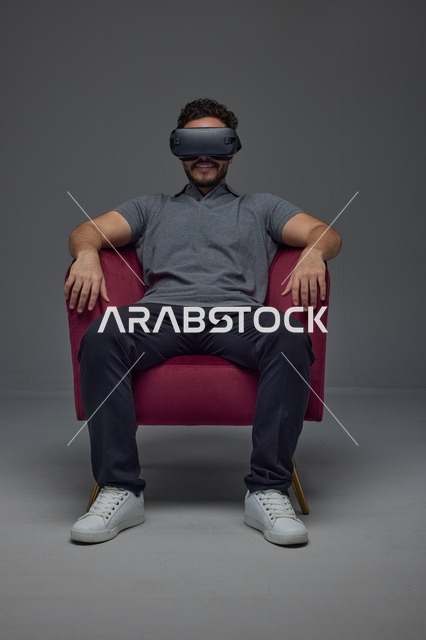 رجل سعودي يستخدم نظارة الواقع الافتراضي ويجلس على كرسي