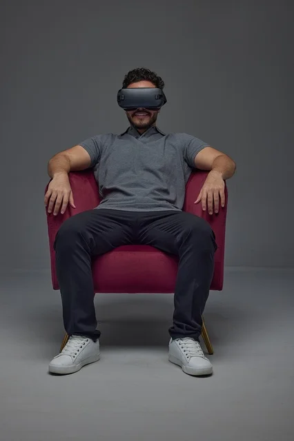 Saudi Man Wearing Virtual Reality Headset in Red Armchair