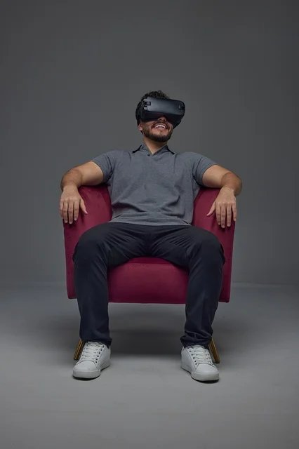 Saudi Man Wearing VR Headset in Red Armchair Studio Shot