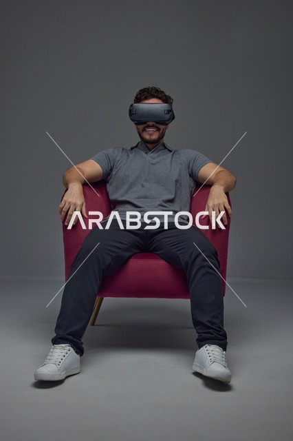 Saudi Man Wearing VR Headset in Red Armchair Studio