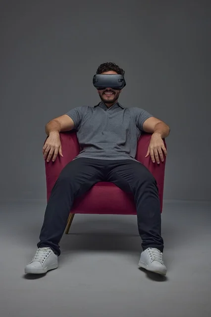 Saudi Man Wearing VR Headset in Red Armchair Studio