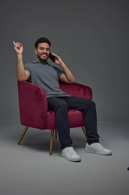 Saudi Man Sitting in Armchair Using Smartphone Studio