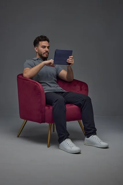 Saudi Man Sitting on Chair Using Digital Tablet