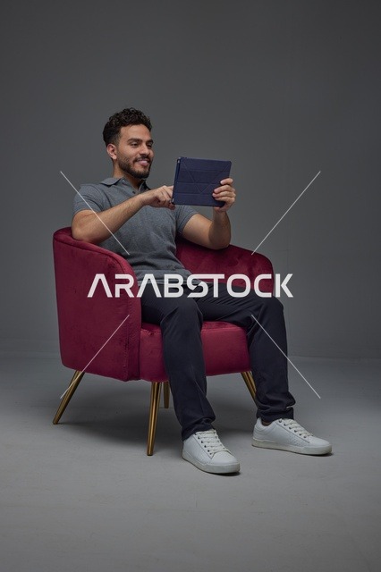 Saudi Man Sitting in Studio Using a Digital Tablet