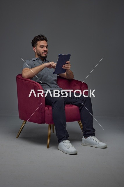 Saudi Man Using Tablet in Studio Armchair