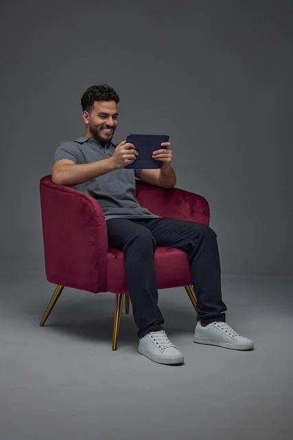 Saudi Man Using Tablet in Armchair Studio Setting