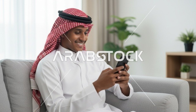 رجل سعودي يستخدم الهاتف الذكي في غرفة معيشة حديثة