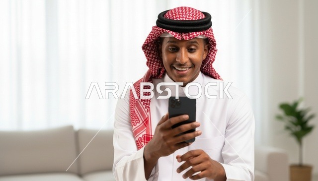 Smiling Saudi Man Using Smartphone in Living Room