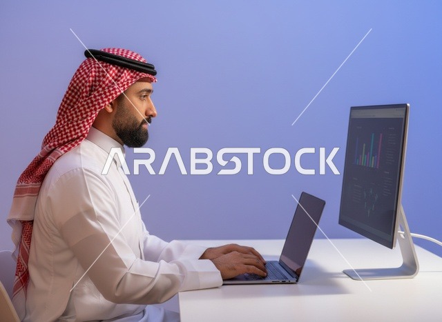 رجل سعودي يعمل على جهاز اللابتوب في المكتب