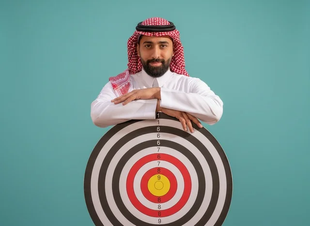 Saudi Man with Dartboard Target for Business Goals