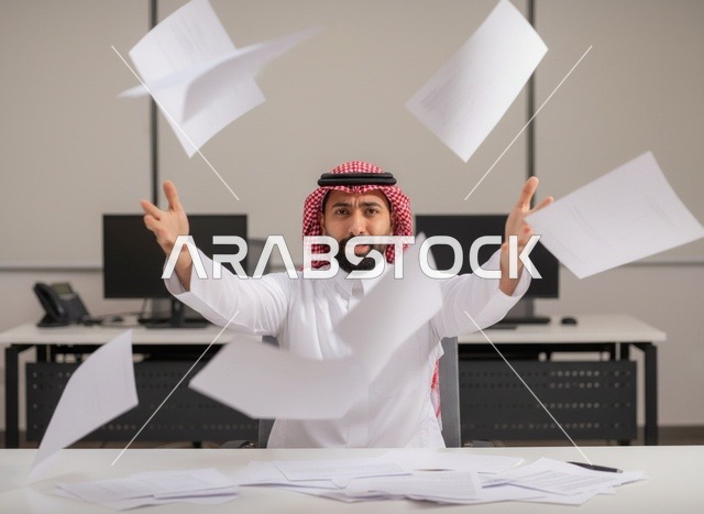 رجل أعمال سعودي محبط يرمي الأوراق في المكتب