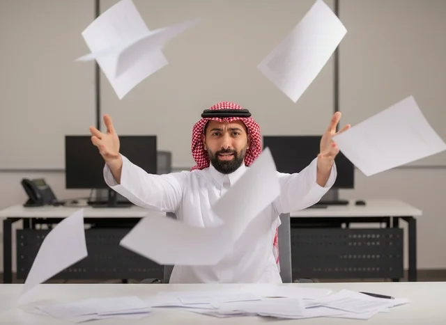 رجل أعمال سعودي محبط يرمي الأوراق في المكتب