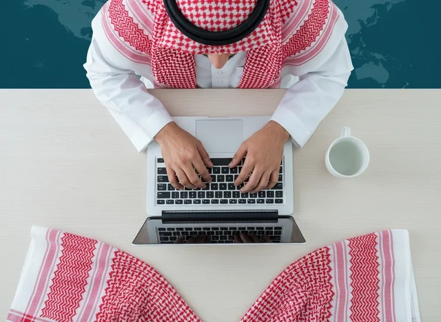 Saudi Businessman Typing on Laptop Top Down View