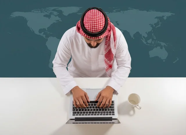 Saudi Businessman Typing on Laptop with World Map
