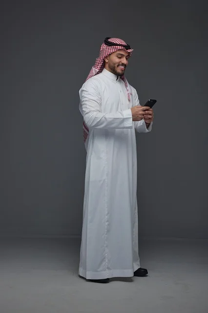 Saudi Man Using Smartphone on Grey Studio Background