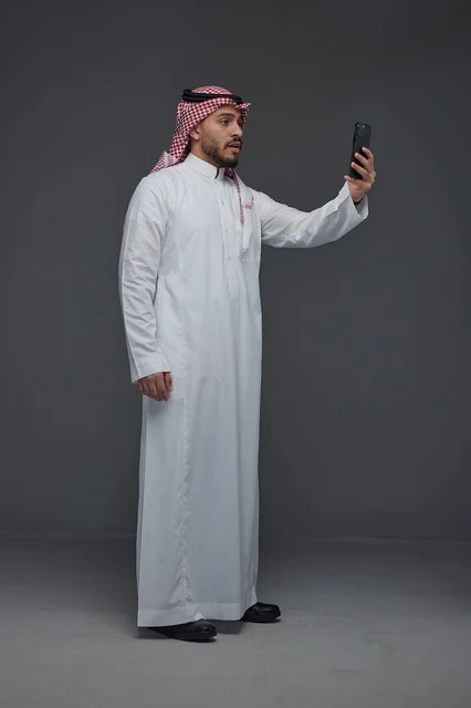 Saudi Man in Traditional Thobe Taking Selfie in Studio