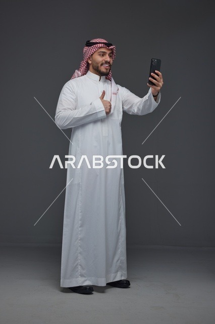 رجل سعودي يلتقط سيلفي بالهاتف الذكي في الاستوديو