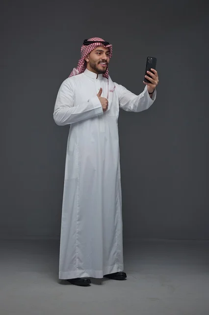 رجل سعودي يلتقط سيلفي بالهاتف الذكي في الاستوديو