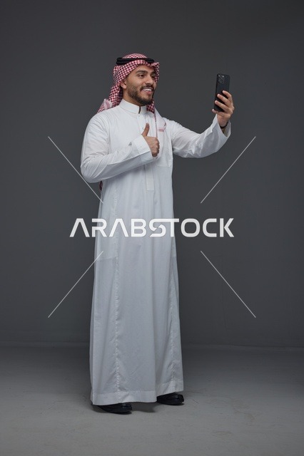 رجل سعودي يلتقط سيلفي مع إيماءة الإعجاب في الاستوديو