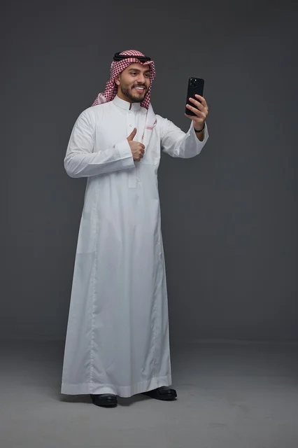 رجل سعودي يلتقط صورة سيلفي بالهاتف الذكي في الاستوديو
