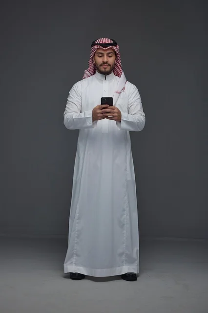 Saudi Man Using Smartphone in Traditional Thobe