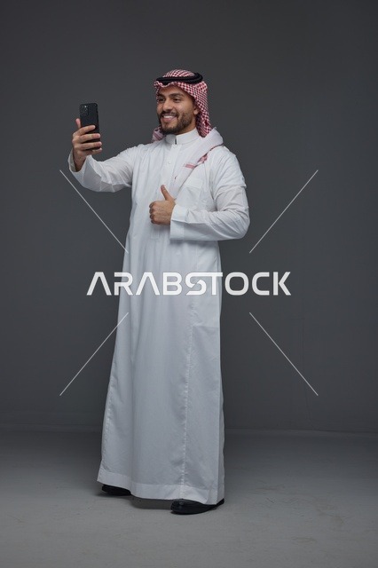 رجل سعودي يلتقط سيلفي مع إشارة الإعجاب