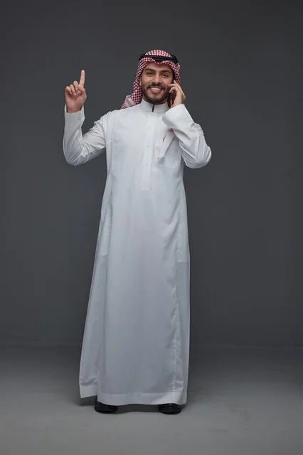 Saudi Man in Traditional Thobe Using Smartphone
