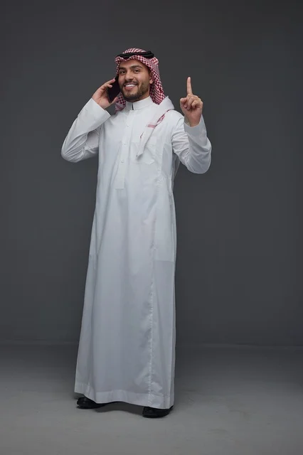 Saudi Man in Traditional Dress Using Smartphone Studio