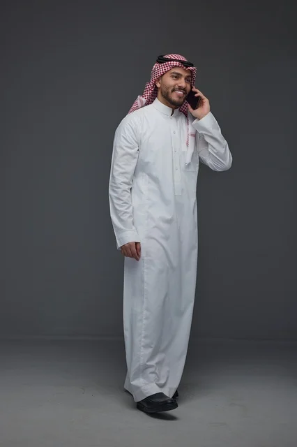 Saudi Man in Traditional Dress on Smartphone Studio Shot